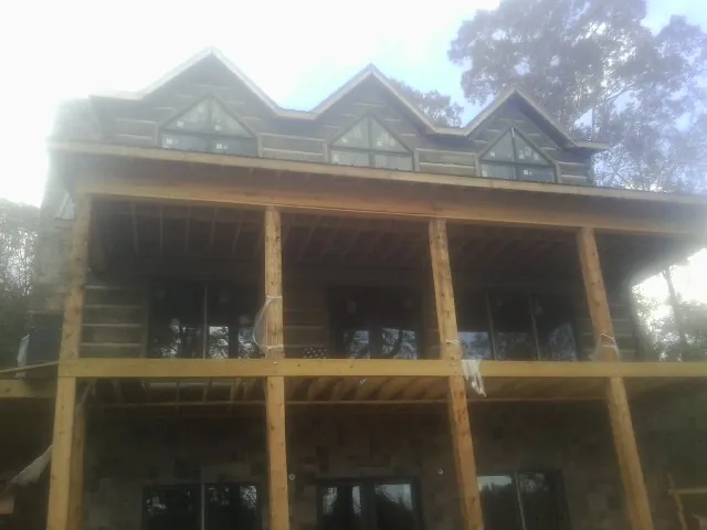 Dormers and porch framing on a large log home under construction — Roof Coating work by our crew in Rosendale